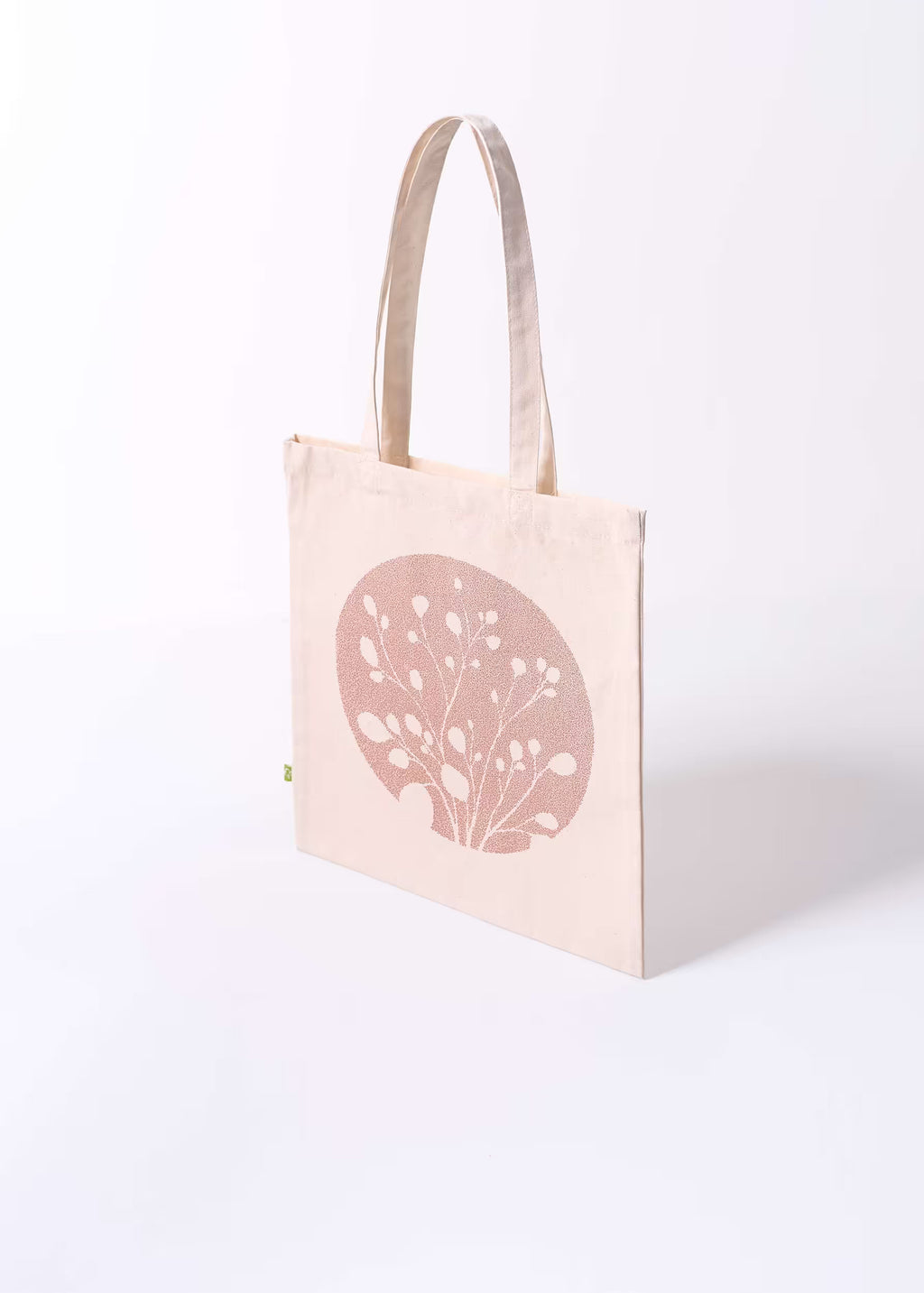 Tote bag Arena Roja Crystal Peppers — vista tres cuartos, serigrafía rosada metalizada sobre lienzo natural de algodón orgánico, etiqueta ecológica verde