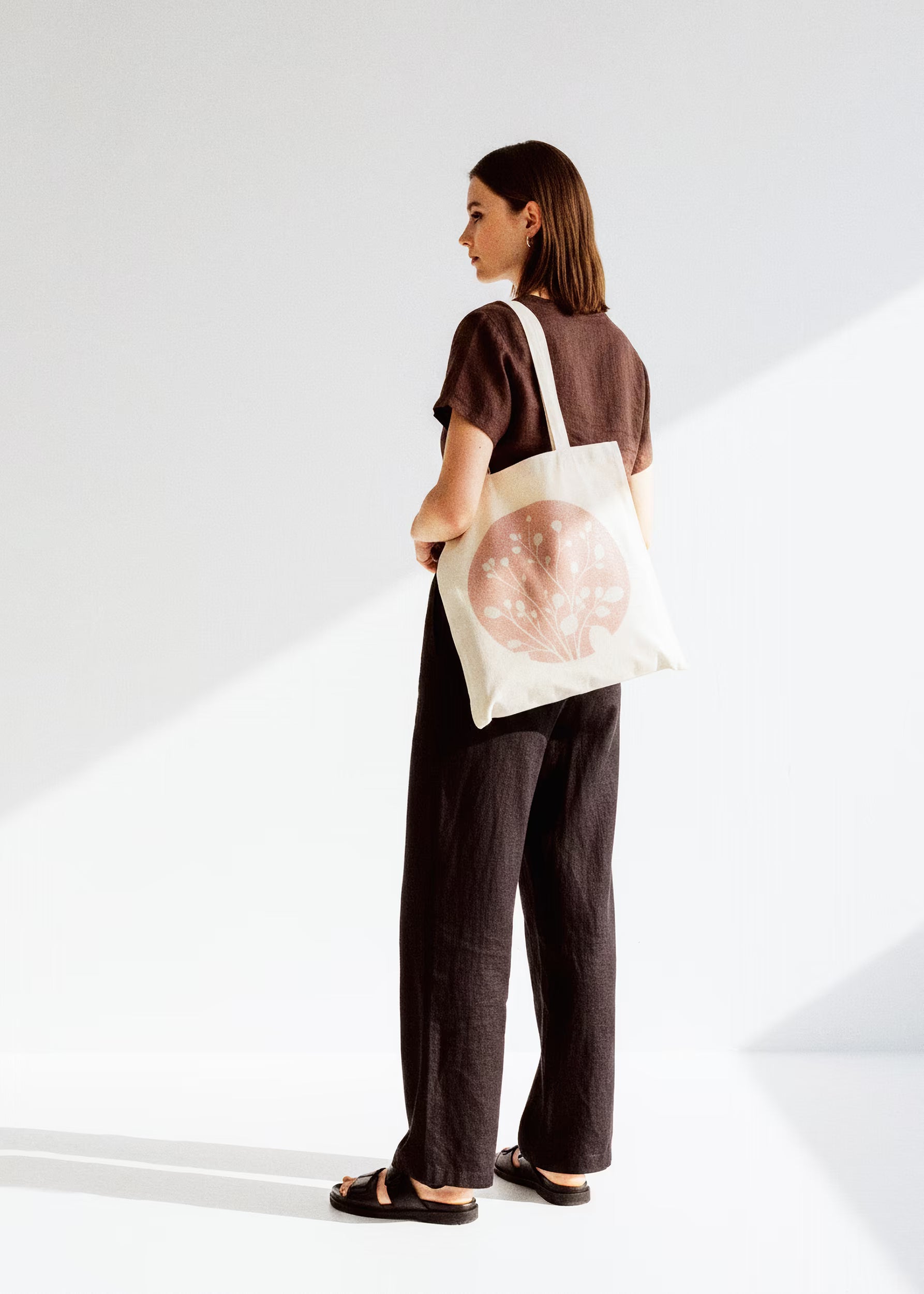 Modelo con tote bag Arena Roja al hombro, look chocolate oscuro — colección Sol y Sombra Crystal Peppers
