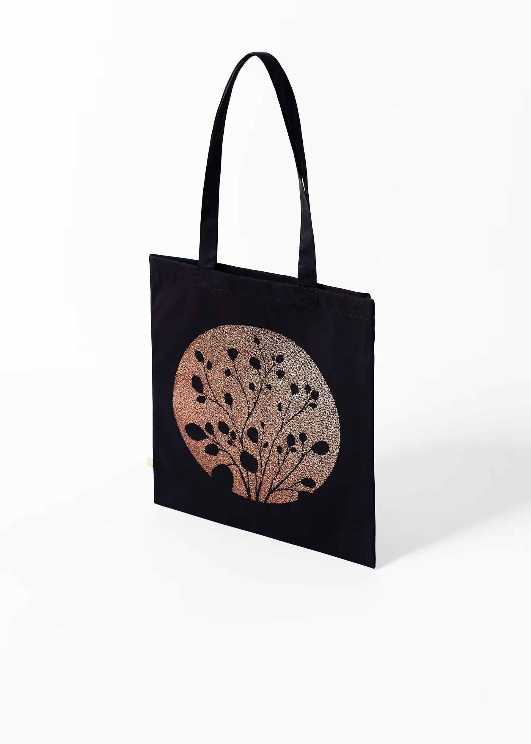 Tote bag Carbón Cobre Crystal Peppers — vista tres cuartos, serigrafía cobre metalizada sobre lienzo negro de algodón orgánico