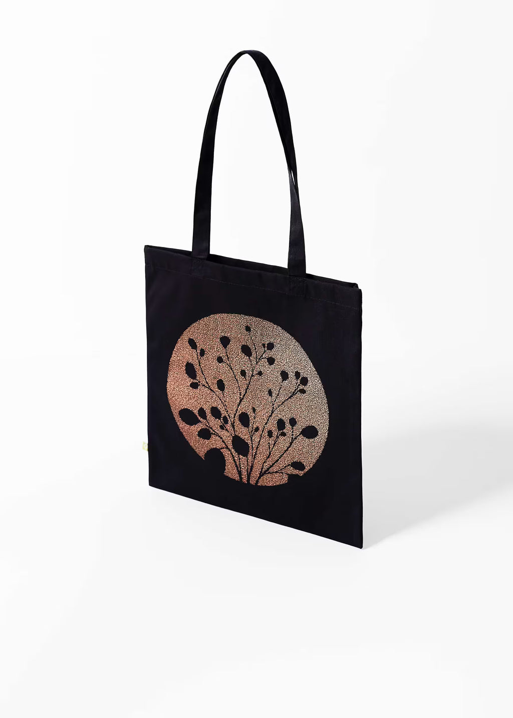 Tote bag Carbón Cobre Crystal Peppers — vista tres cuartos, serigrafía cobre metalizada sobre lienzo negro de algodón orgánico