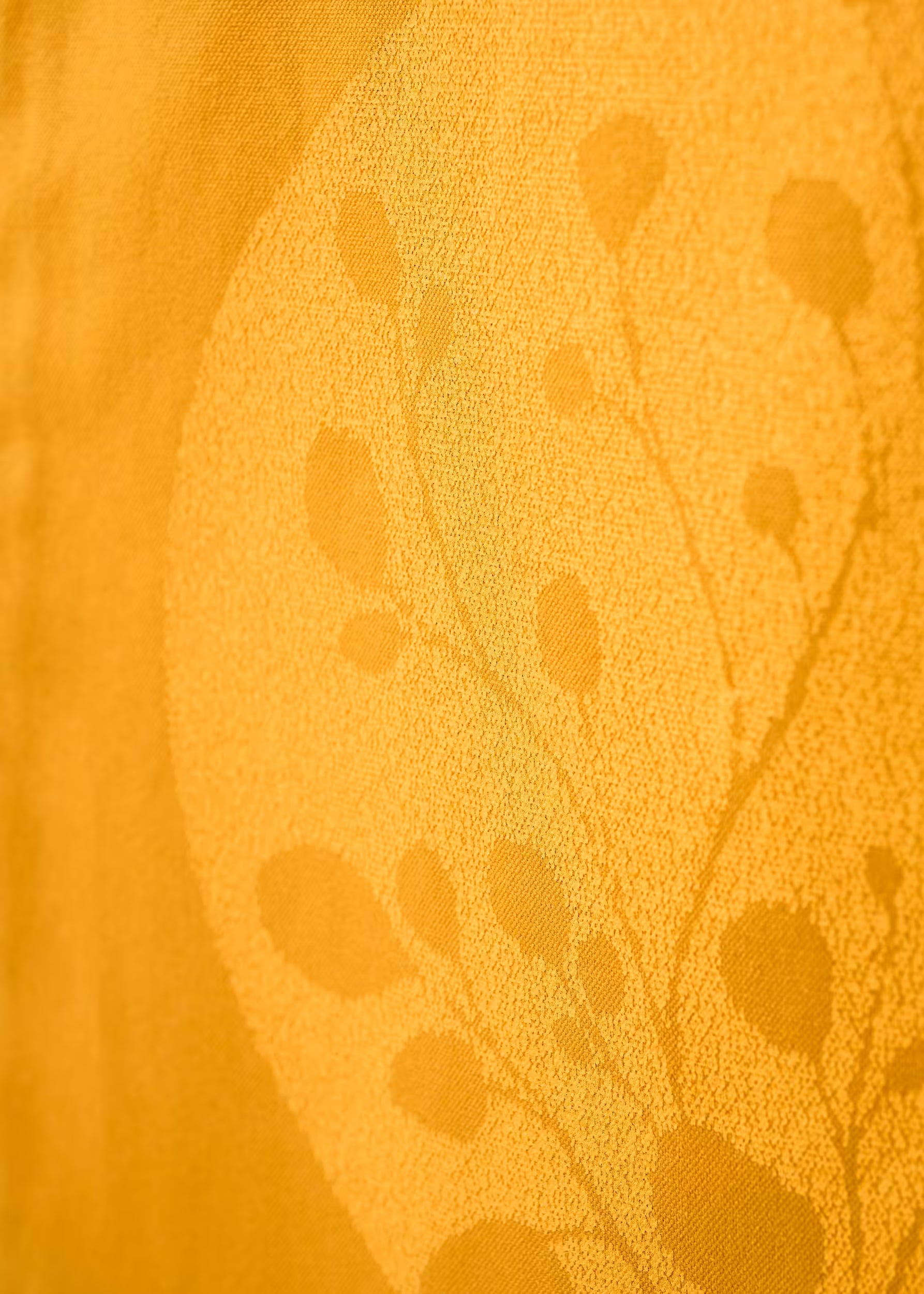 Macro de la serigrafía tono sobre tono del tote bag Gold Nugget — motivo botánico amarillo sobre ocre, tinta ecológica