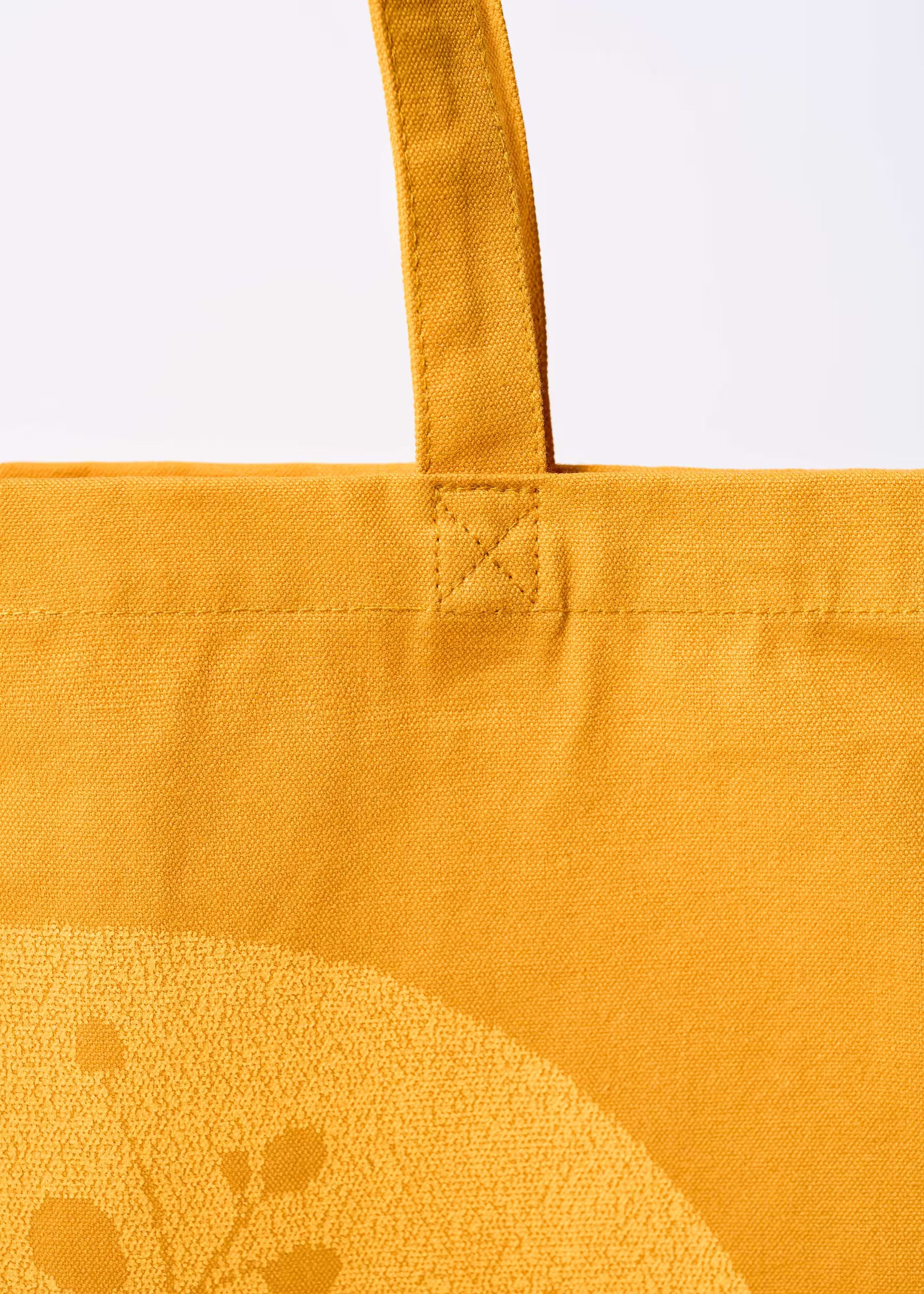 Detalle del asa y costura superior del tote bag Gold Nugget — algodón orgánico ocre, costura reforzada